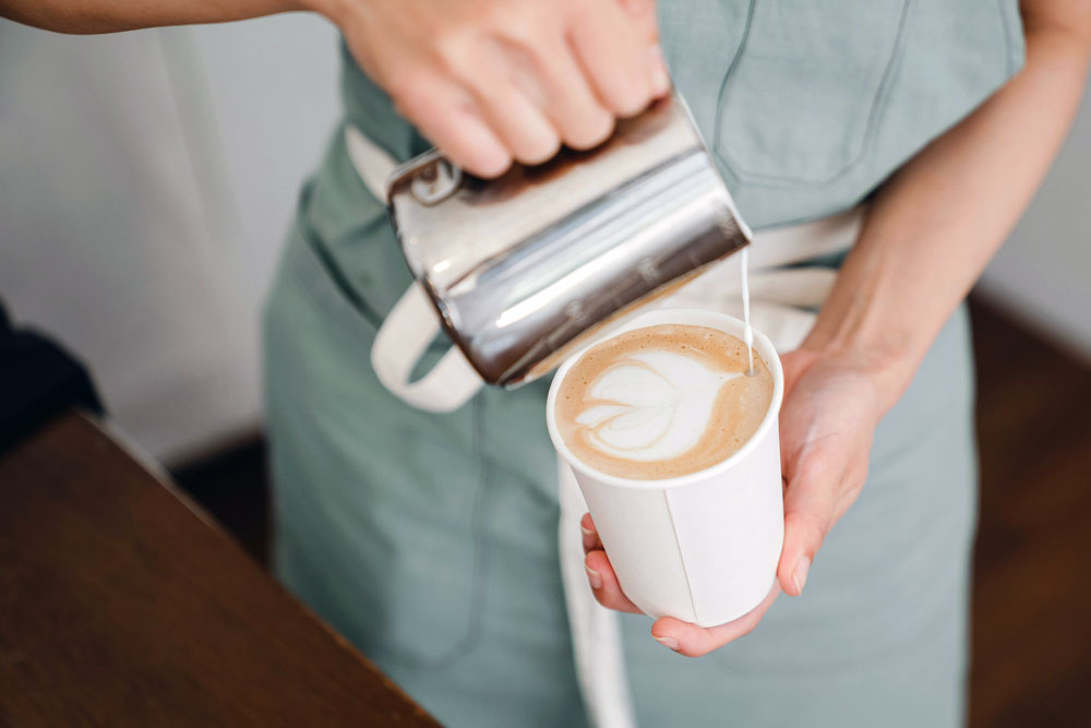 A picture of someone pouring a latte