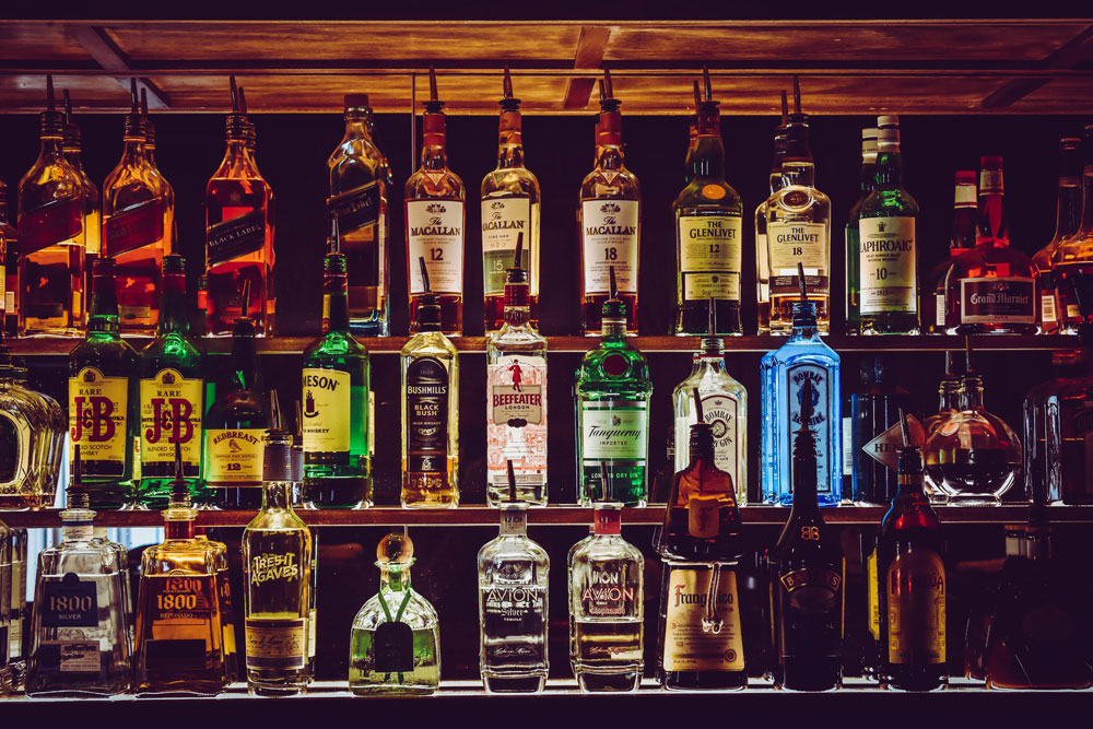 A fine selection of bottled spirits in front of a mirror